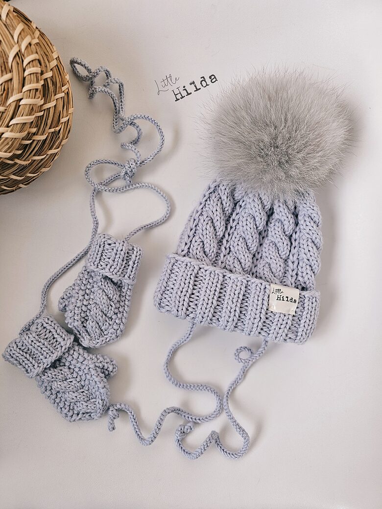 Hat with narrow braids and a faux fur pom-pom